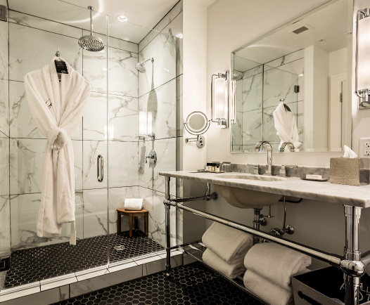 Fresh linens, towels, and a bathrobe in a hotel bathroom in Beloit, WI.